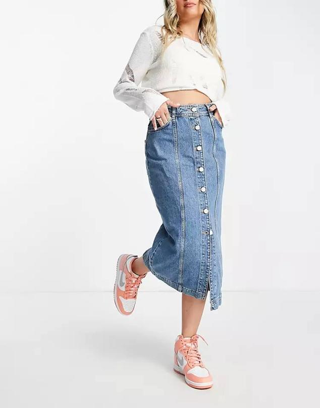 Falda de tubo midi en tejido denim con tiro alto, bolsillos, costuras decorativas y cierre de botones frontal, en azul medio, de Whistles. Cuesta 73,99 euros, en Asos.