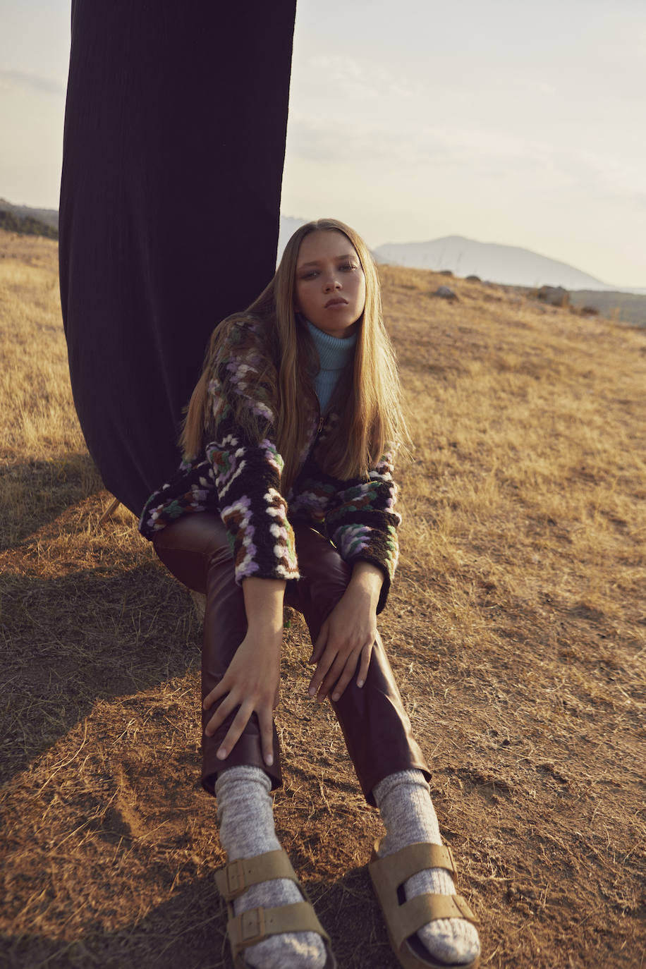 Jerseys de crochet y azul de cuello alto, de Samsøe Samsøe; pantalón de piel, de Chanel; y sandalias y calcetines de Birkenstock.