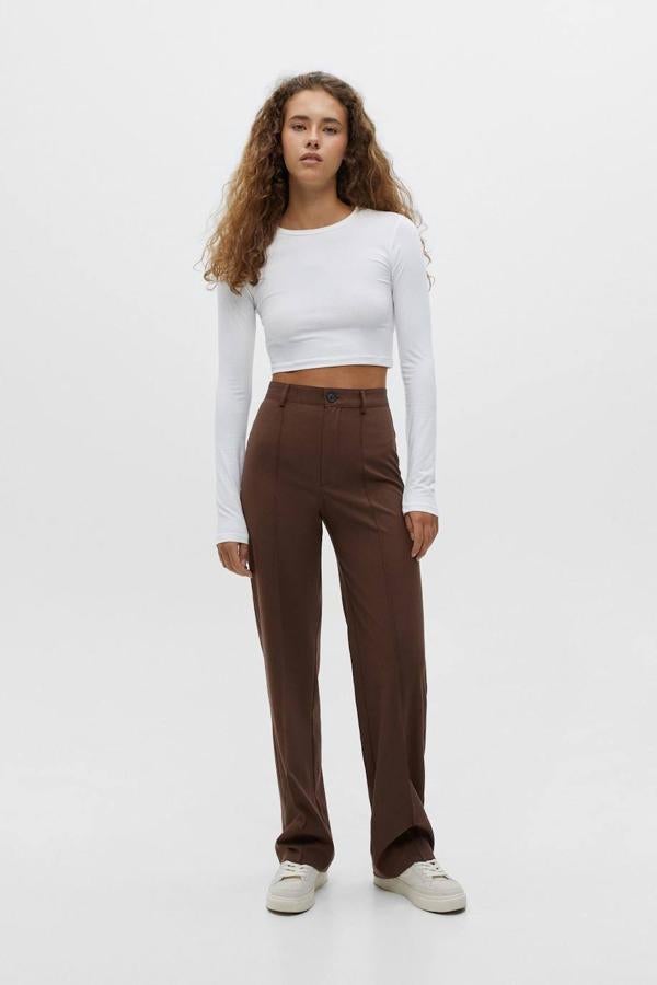 Pantalones de vestir con tiro alto, perneras rectas y detalle de nervio en el delantero, de Pull&Bear. Está disponible en 10 colores, por 22,99 euros.