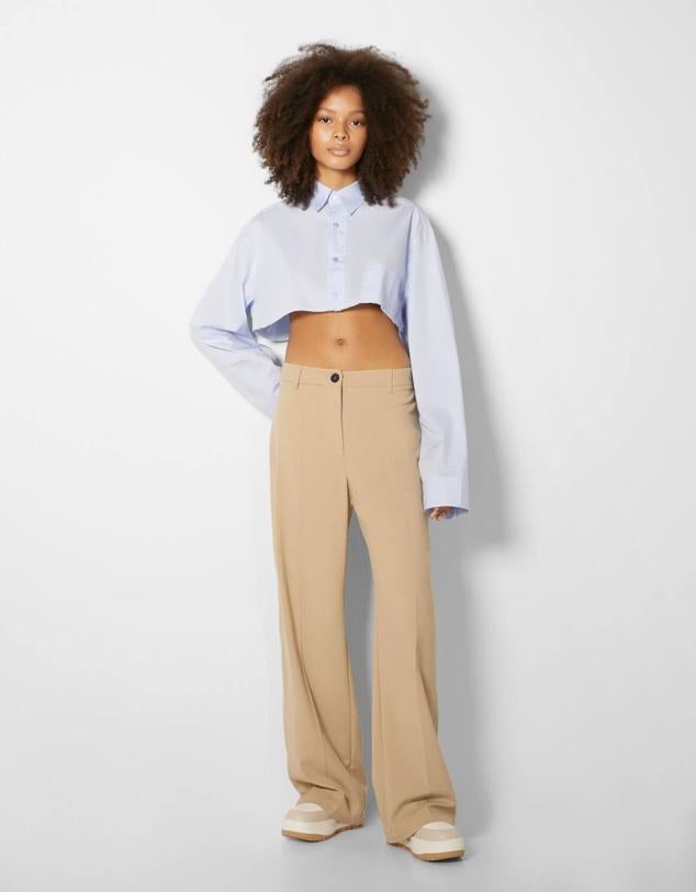 Pantalón de vestir wide leg con tiro medio, trabillas para el cinturón y perneras anchas, de Bershka. Los comprarás en ocho colores, a 25,99 euros.