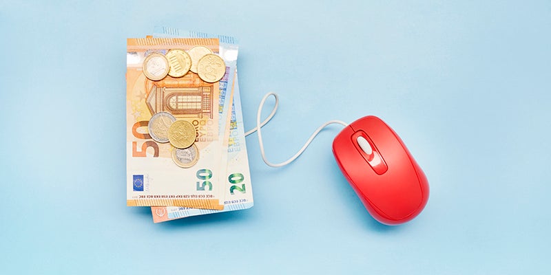 High abgle view of Euro banknotes and computer mouse on blue background