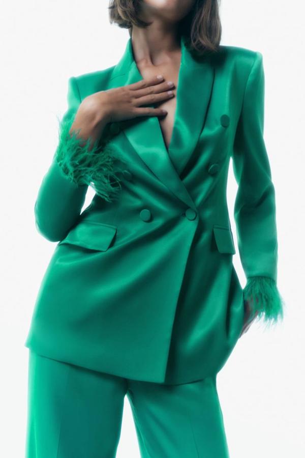 Blazer entallada con diseño cruzado de doble botonadura, bolsillos y mangas largas con hombreras y aplicación de plumas a tono, color verde, de Zara. Tiene un coste de 69,95 euros.
