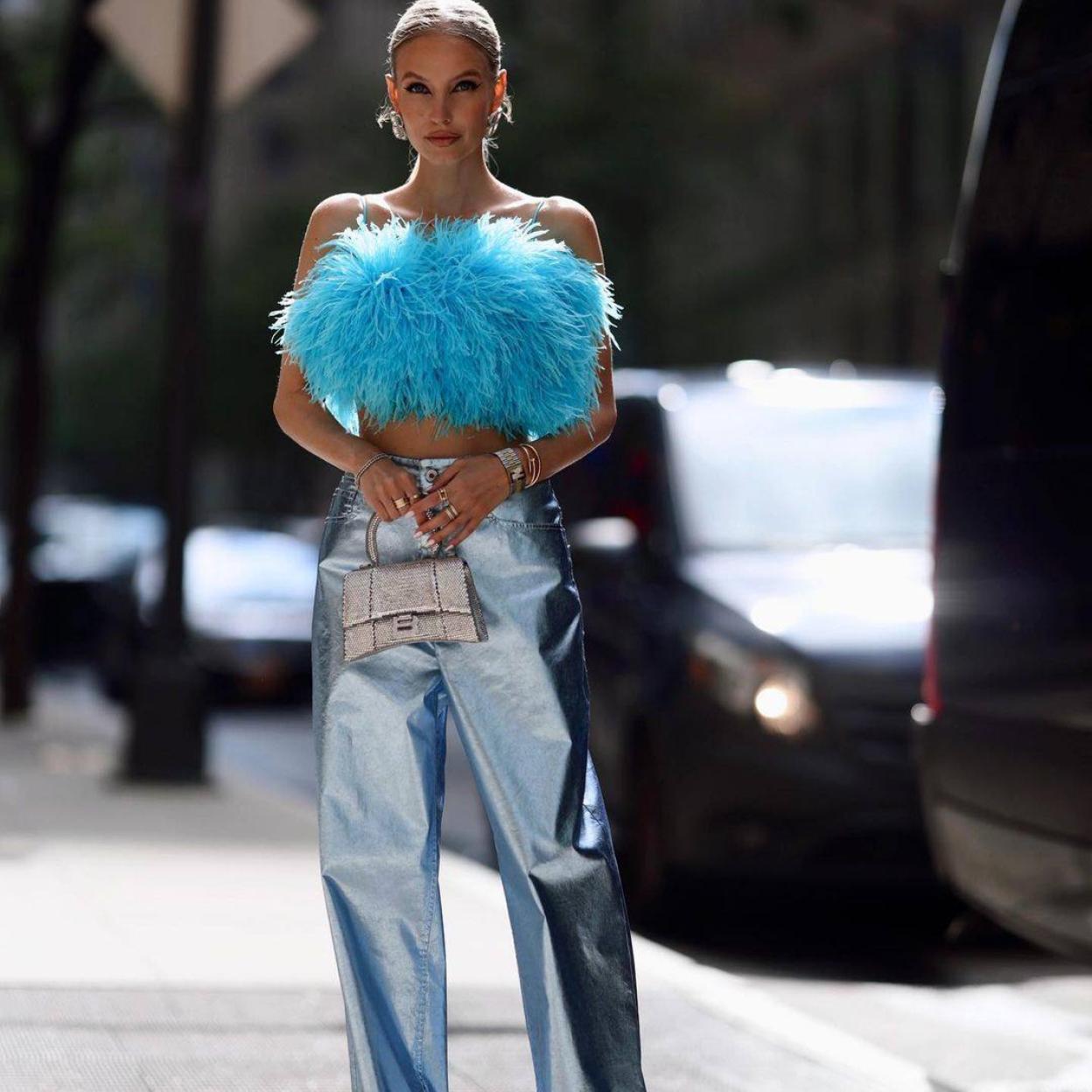 La influencer lleva un look de fiesta con pantalón metalizado y top de plumas
