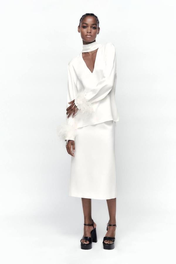 Falda de tubo midi en tejido satinado con tiro alto y corte recto y ajustado, de Zara. Su precio es de 39,95 euros.