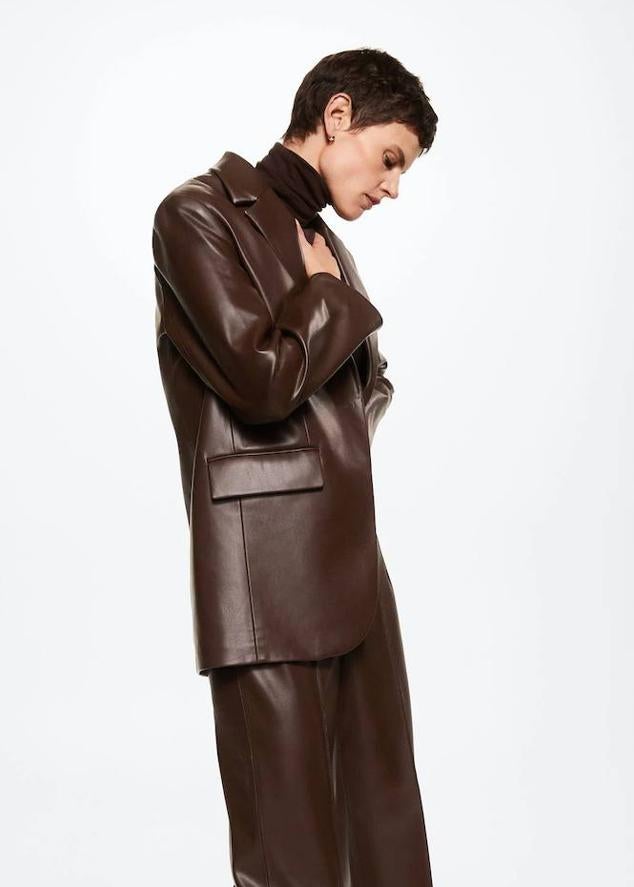Americana oversize en tejido efecto piel con manga larga, cuello solapa con muesca, bolsillos y cierre simple de botón, color marrón oscuro, de Mango. Puedes comprarla a 69,99 euros.