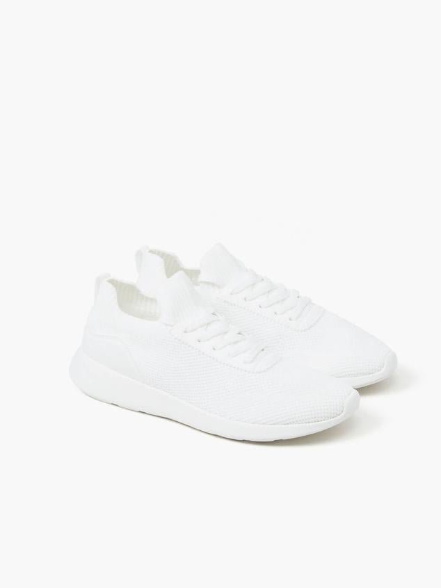 Zapatillas en tejido elástico tipo calcetín, diseño running, suela curvada y cierre de cordones, de Lefties. Puedes comprarlas a 11,99 euros.