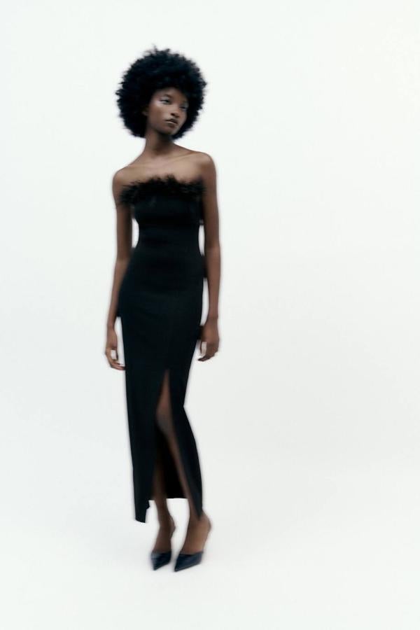 Vestido midi entallado con abertura en el bajo, escote recto con hombros al descubierto y detalle de plumas, color negro, de Zara. Está disponible por 49,95 euros.
