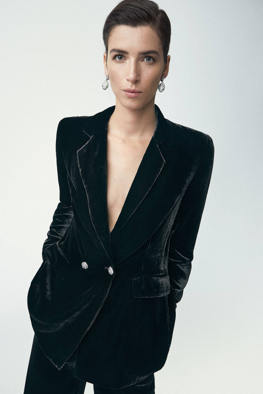 Traje de chaqueta y pantalón de Woman Fiesta, en El Corte Inglés. Los pendientes son de Bvlgari.