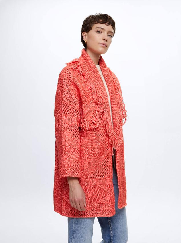 Poncho en tejido de punto con patrón étnico, manga larga, diseño abierto y cuello solapa con flecos, en naranja. Lo encontrarás a 49,99 euros.