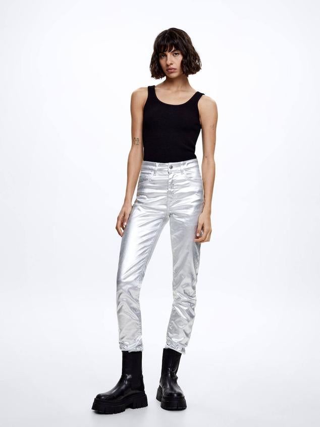 Pantalón pitillo confeccionado en tejido con acabado metalizado, tiro alto, trabillas, bolsillos y pernera ajustada, en plata. Está disponible por 35,99 euros.