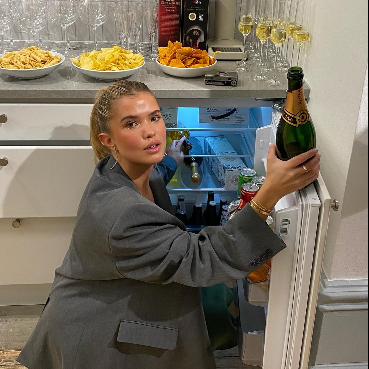 Influencer abriendo la nevera con una botella de champán