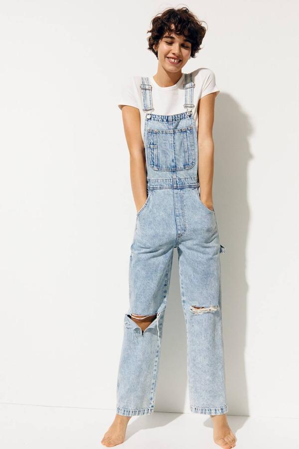 Peto carpenter en tejido denim lavado a piedra con perneras rectas y anchas, detalles rotos, tirantes anchos ajustables y bolsillos, color azul claro, de H&M. Puedes comprarlo por 29,99 euros.