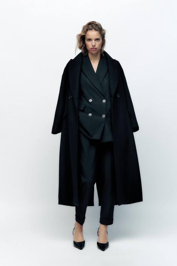 Pantalón de traje con perneras rectas acomodadas al cuerpo y terminadas en vuelta, tiro alto, bolsillos y pinzas laterales, en print de raya diplomática negro. Cuesta 29,95 euros.