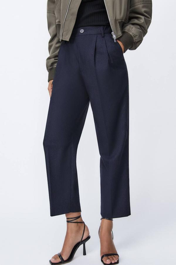 Pantalón de vestir tobillero con perneras anchas y cropped, detalle de pinzas, trabillas y bolsillos, en estampado de raya diplomática azul marino. Hazte con ellos a 29,95 euros.