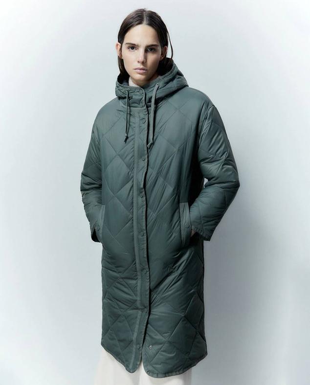 Parka larga acolchada con guateado de diamante, tejido ligero, capucha y bolsillos, color verde metal, de Sfera. Su precio es de 49,99 euros.