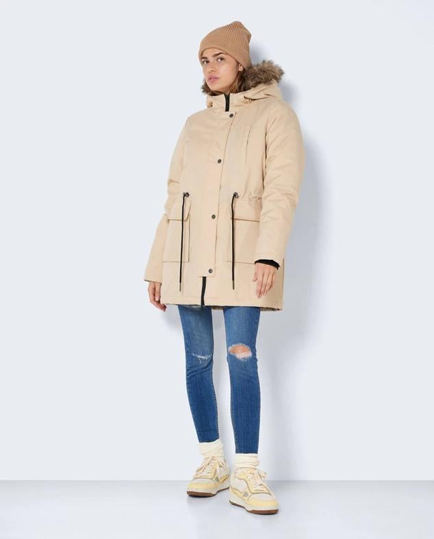 Parka oversize con cuello alto, capucha con perlo, bolsillos de plastrón y cintura ajustable con stopper, en beige, de Noisy May. Hazte con ella en El Corte Inglés a 59,99 euros.