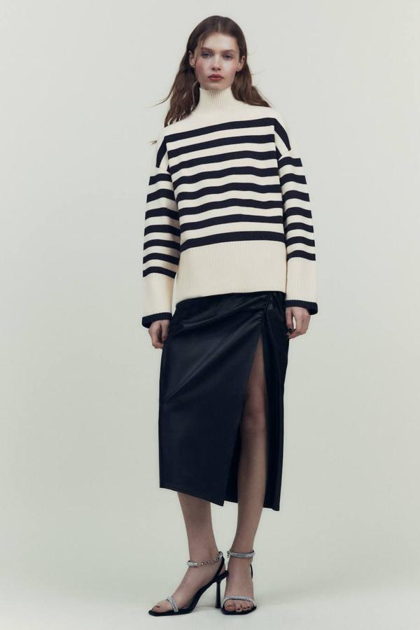 Jersey en tejido de punto con corte amplio, manga larga, cuello alto, terminaciones en rib y print a rayas crudo y negro, de Zara. Lo encontrarás a 29,95 euros.
