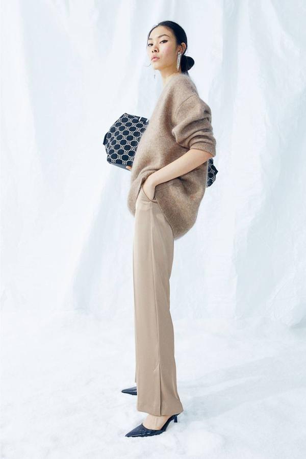 Pantalón de vestir en tejido satinado con tiro alto, bolsillos y bajo acabado en abertura, de H&M. Puedes comprarlos en tres tonos, por 24,99 euros.