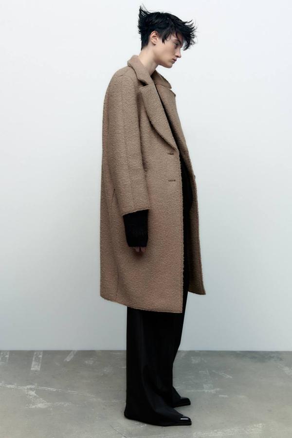 Abrigo en tejido bouclé con corte relajado, manga larga, cuello solapa con muesca y bolsillos a los lados, en tostado, de Zara. Cuesta 59,95 euros.