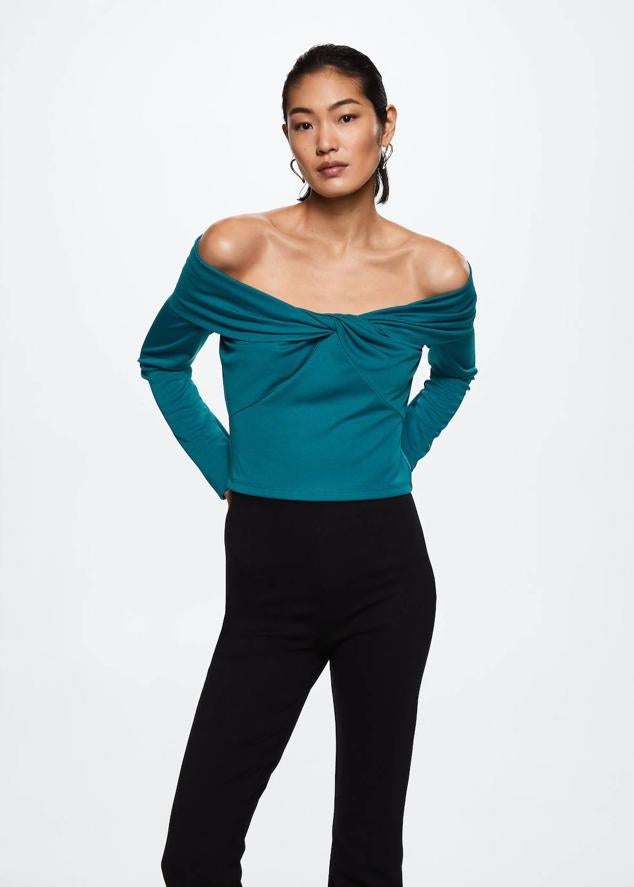 Camiseta con escote recto, hombros al descubierto, detalla de nudo y manga larga, en tono turquesa, de Mango. Su precio es de 25,99 euros.