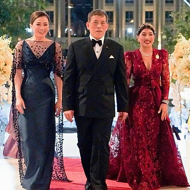 El rey Maha Vajiralongkorn (Rama X), a la izquierda la reina Suthida y a la derecha, de rojo, la princesa Sirivannavari.