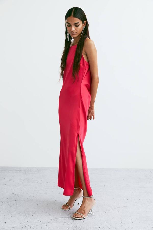 Vestido lencero largo en tejido satinado con espalda drapeada decorada con tiras de strass y abertura en el bajo, color fucsia, de H&M. Te costará 59,99 euros.