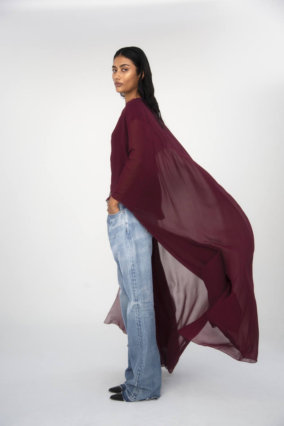 Capa drapeada de seda, vaqueros, botas, cinturón y pendientes, todo de Celine by Hedi Slimane.