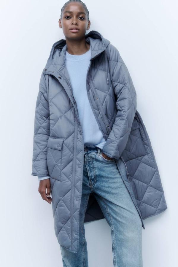 Abrigo largo en tejido acolchado resistente con capucha, manga larga, bolsillos y cierre de cremallera, en azul claro, de Zara. Consíguelo por 69,95 euros.