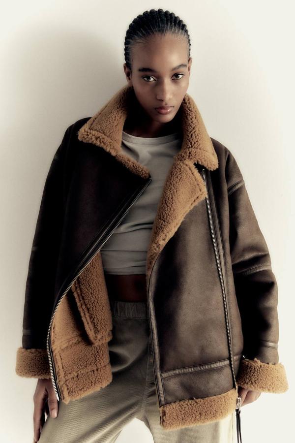 Cazadora de doble faz con interior de borreguillo, cuello alto, manga larga, bolsillos y cierre cruzado con cremallera, en marrón.