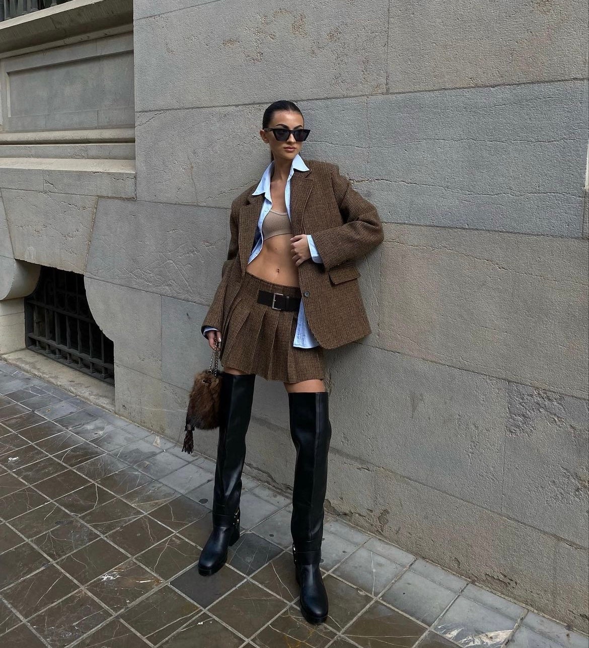 El triunfo sin precedentes de las botas altas ha sido tan fuerte que en algunos casos hasta ha rebasado unos cuantos centímetros la rodilla. Sin duda este tipo de diseño se convierte en el centro de los looks más rompedores. Prueba de ello es el estilismo que muestra Meri Lozano (la hermana pequeña de Marta Lozano). La joven valenciana muestra que la capacidad de combinar las botas altas es muy alta. La influencer las luce con un traje de dos piezas integrado por una americana y una falda plisada. 