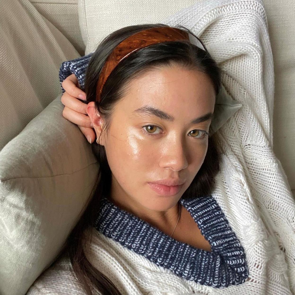 Una mujer con crema en el contorno de ojos.