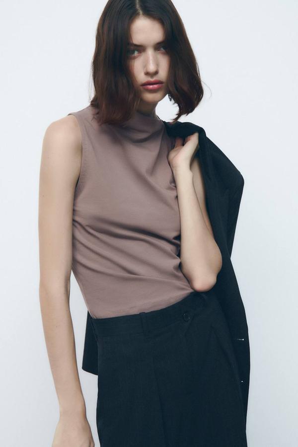 Camiseta básica con manga sisa y cuello perkins asimétrico. Tiene un coste de 7,95 euros, en tres tonos.