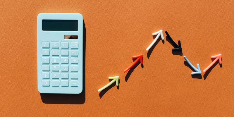 Blue calculator and a graph made from colored arrows. Brown background. Multi-colored lines in the graphics. Blue calculator.