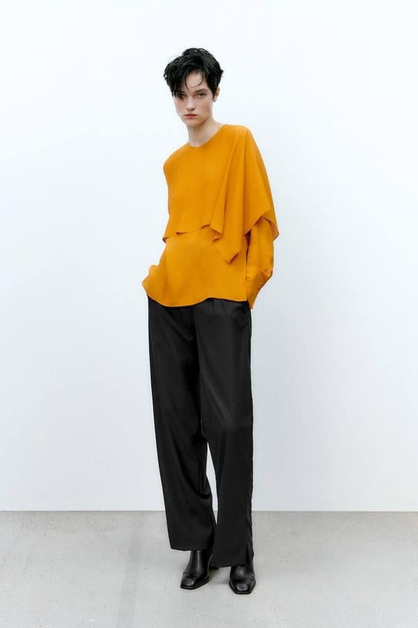 Blusa fluida con sobreposición a modo de capa, cuello recto y manga larga, en mostaza, de Zara. Hazte con ella rebajada a 12,99 euros.