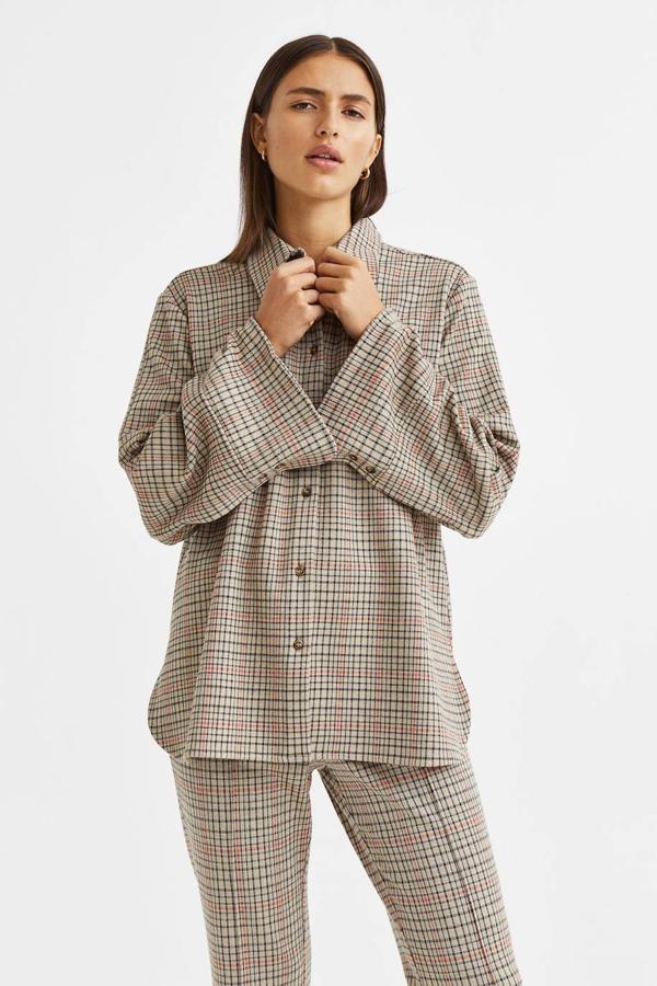 Camisa oversize en tejido de punto suave con cuello solapa y manga larga, en estampado de cuadros marrón, de H&M. Cuesta 29,99 euros, con descuento.