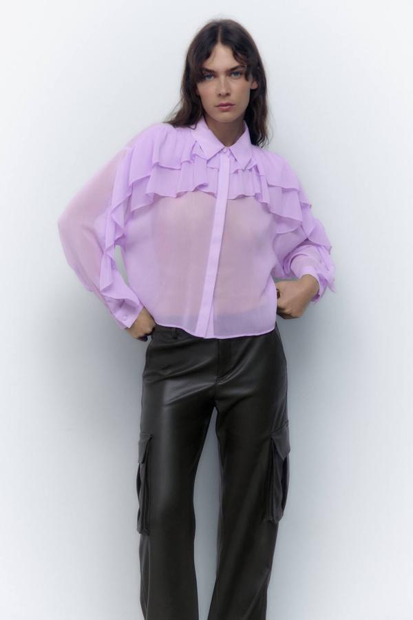 Blusa fluida en tejido semitransparente con detalle de volantes, cuello solapa y manga larga, tono lila, de Zara. La conseguirás en rebajas por 15,99 euros.