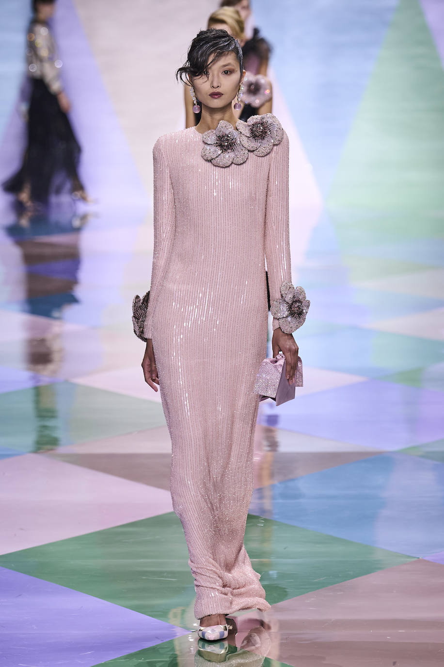 Armani Privé se inspira en el mundo de los arlequines y nos deja propuestas tan sofisticadas como este elegantísimo vestido hoya en pailletes rosa empolvado con detalle de flores.