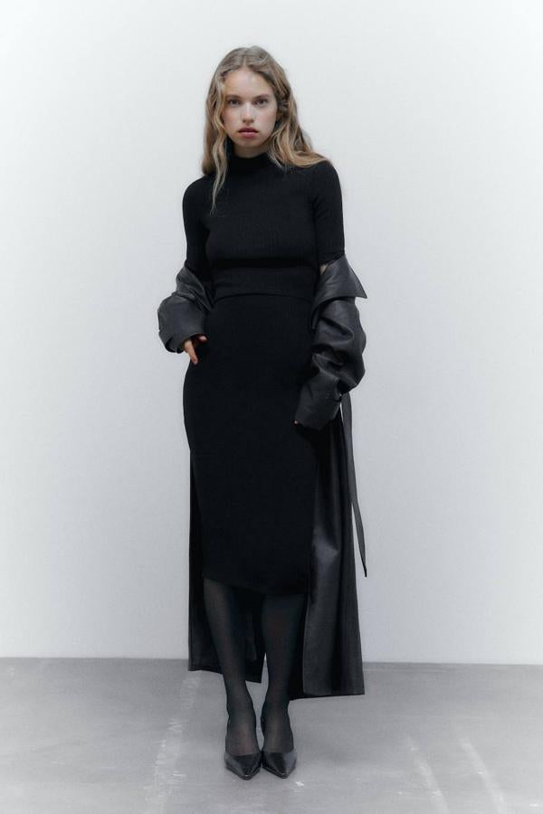 Falda midi de tubo en tejido de punto rib con tiro alto y cintura elástica, color negro. Cómprala con descuento a 9,99 euros.