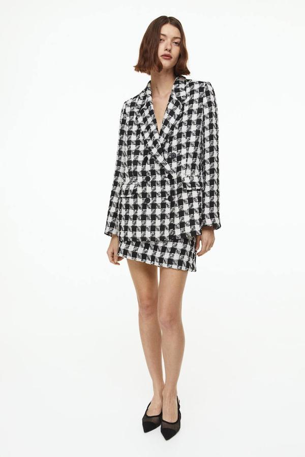 Conjunto de tweed con blazer cruzada y minifalda, en estampado a cuadros, negro y blanco, de H&M. Te costará 44,99 euros y 19,99 euros.