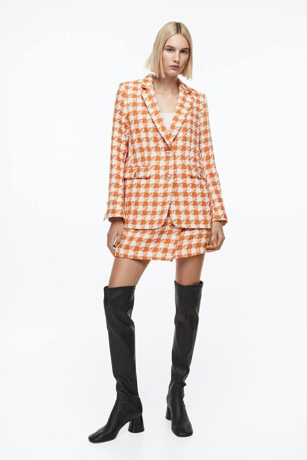 Conjunto de tweed con blazer y falda corta cruzado, en print a cuadros naranja, de H&M. Hazte con él por 49,99 euros y 34,99 euros.