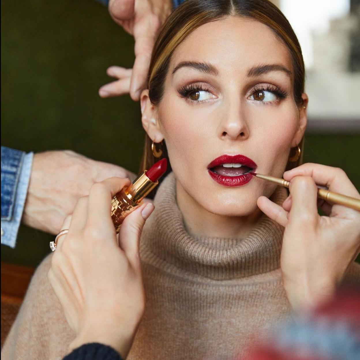 Olivia Palermo mientras le maquillan los labios.