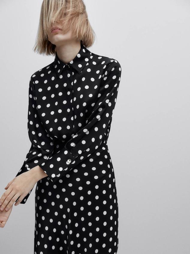 Blusa fluida con cuello solapa, manga larga terminada en puño ancho y estampado de lunares, en blanco y negro. Podrás conseguirla por 99,95 euros.