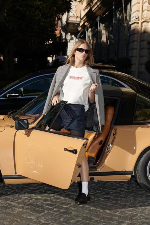 Look con camiseta básica con mensaje a 15,95 euros, shorts, blazer de vichy y mocasines con calcetines blancos.