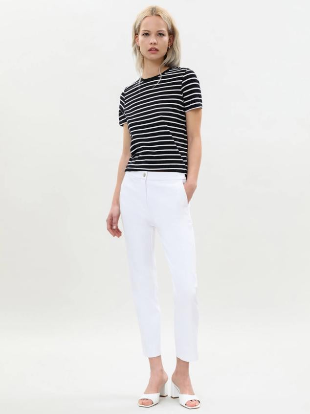 Pantalón entallado de tiro medio con cintura elástica en la espalda, color blanco, de Lefties. Está disponible por 15,99 euros.