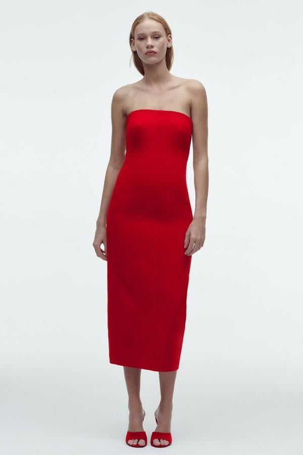 Vestido midi de tubo con costuras de estructura y pecho pronunciado, escote recto, hombros al descubierto, abertura en el bajo y elástico tipo nido de abeja, color rojo, de Zara. Lo encontrarás a 49,95 euros.