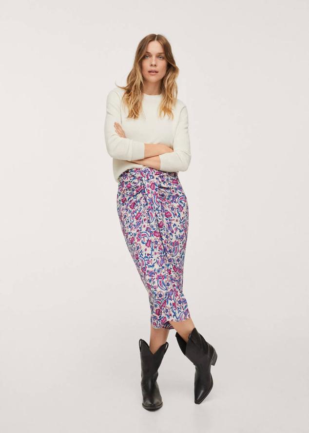 Falda midi con diseño acomodado al cuerpo, tipo alto, detalle de nudo delantero y abertura en el bajo, en estampado de flores crudo y morado. Cuesta 17,99 euros.