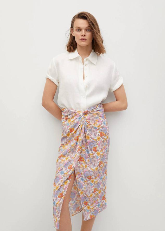 Falda midi con tiro alto, abertura en el bajo y detalle drapeado, en floral print multicolor. Está disponible a 17,99 euros.