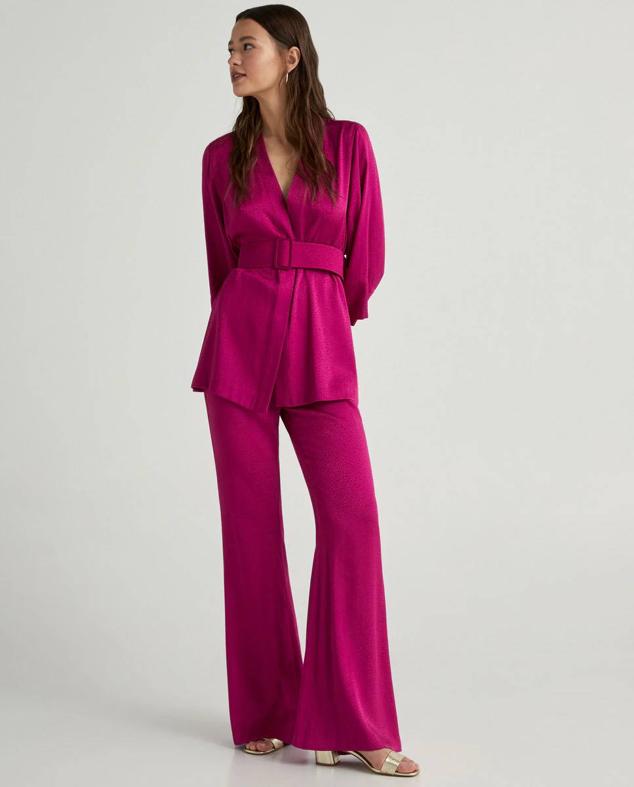 Traje jacquard con acabado brillante compuesto por blazer con cinturón tipo kimono y pantalón acampanado, en fucsia, de Green Coast. Su precio es de 59,99 euros y 49,99 euros.