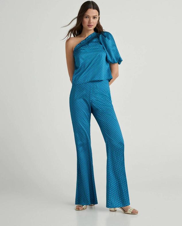 Conjunto con top asimétrico con manga abullonada y pantalón fluido acampanado, en print geométrico azul, de Green Coast. Hazte con él a 39,99 euros y 49,99 euros.