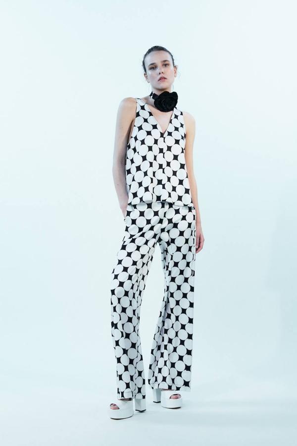 Conjunto con blusa de manga sisa con escote de pico y pantalón ancho, en print de lunares blanco y negro, de Sfera. Encuéntralo a 17,99 euros y 23,99 euros.